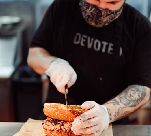 City Barbeque teammate cutting sandwich